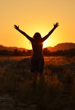 Eller yukarı Günbatımı ile kız.