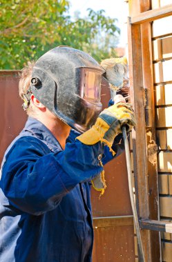 Kaynakçı maskeli mavi gökyüzüne karşı operasyon sırasında