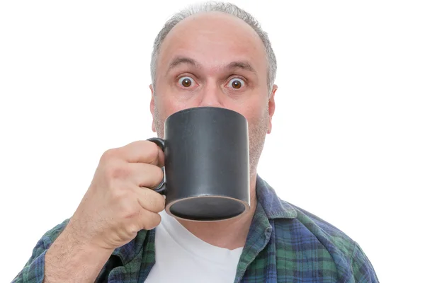 Förvånad person med kopp framför ansikte — Stockfoto