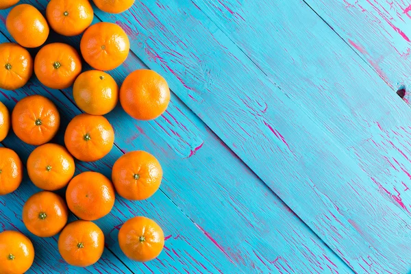 Coloridas mandarinas naranjas en una mesa de picnic azul —  Fotos de Stock