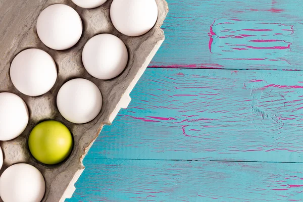 Egg box of white Easter eggs with one green one — Stock Photo, Image