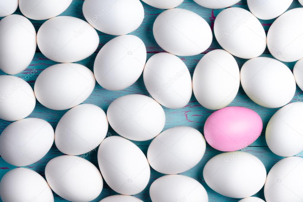 Large number of white Easter eggs and one pink one