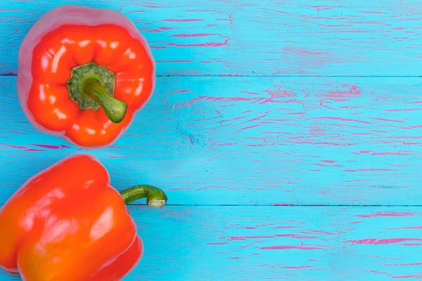 Orange bell peppers over blue wood background — Stock Photo, Image