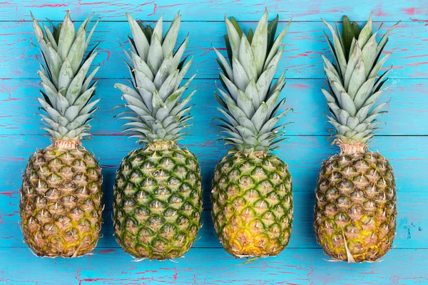 Four pineapples beside each other on table — Stockfoto