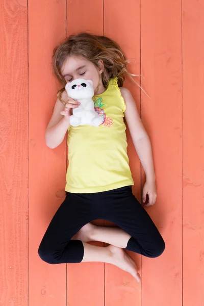 Menina bonito dormindo com seu gato brinquedo de pelúcia — Fotografia de Stock