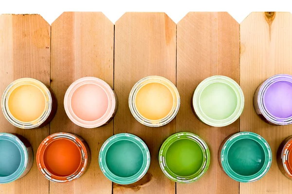 Pots of colorful wood stain on a fence — Stock Photo, Image