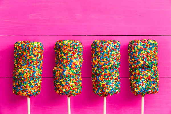 Quatro doces coloridos cobertos de marshmallows — Fotografia de Stock