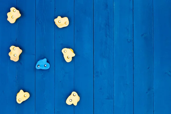 木製の青い壁に 7 つの登山グリップ — ストック写真
