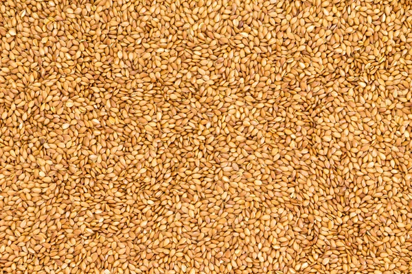 Background texture of roasted golden flax seed — Stock Photo, Image