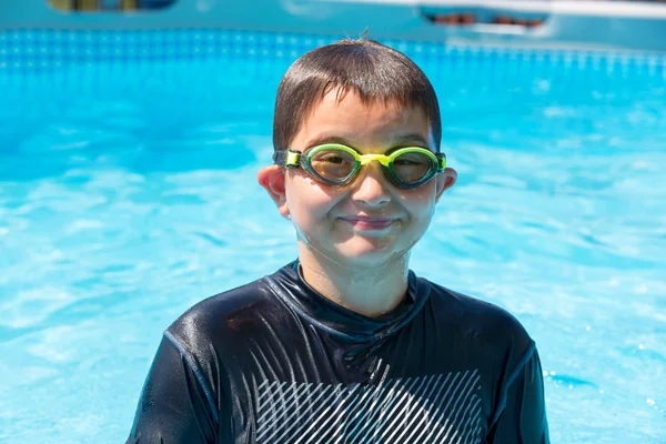 Muchacho sonriente con camisa de baño y gafas en la piscina —  Fotos de Stock