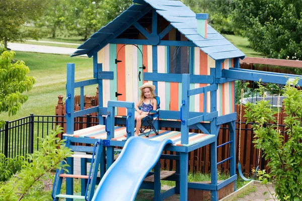 Little girl in chair on outdoor playset — Stock Photo, Image
