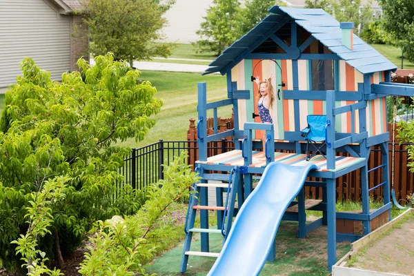 Child on personal playground set waving hands — Stock Photo, Image