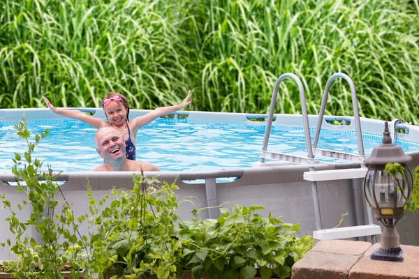 Gelukkig vader en dochter in een zwembad — Stockfoto