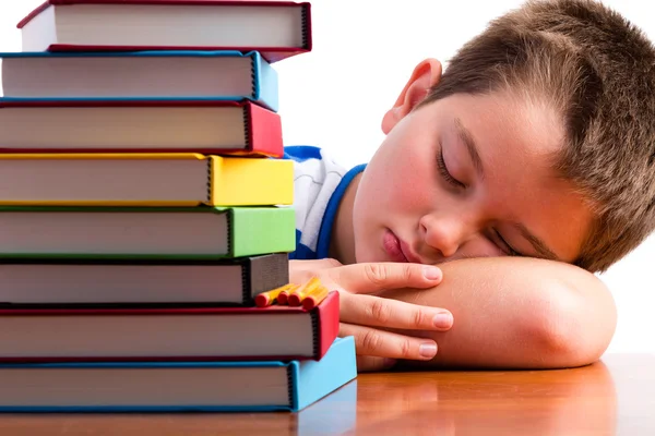 Verveeld of overwerkte schooljongen in slaap op zijn Bureau — Stockfoto