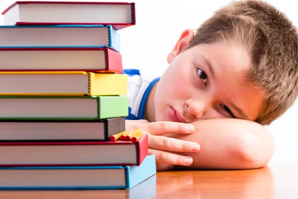 Déprimé jeune écolier regardant ses manuels scolaires — Photo