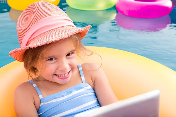 Sonriente chica rubia flotando en tubo interior amarillo —  Fotos de Stock