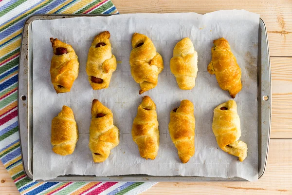 Freshly baked tray of hot dog croissants — Stock Photo, Image