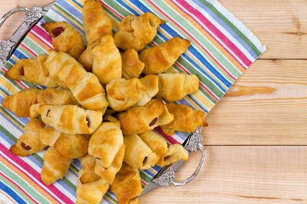 Un mucchio di deliziosi croissant di hot dog freschi — Foto Stock