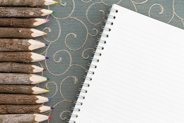 Μολύβι χρωματιστά μολύβια και ένα κενό σημειωματάριο — Φωτογραφία Αρχείου