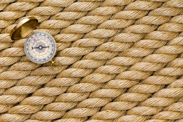 Small magnetic compass on diagonal strands of rope — Stock Photo, Image