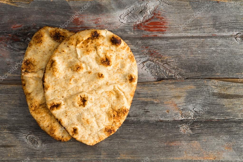 Simply delicious baked naan flatbreads on Picnic Table Stock Photo by