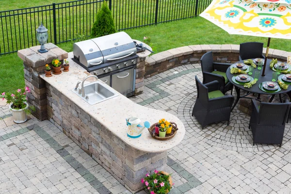 Outdoor kitchen and dining table on a paved patio — Stock Photo, Image