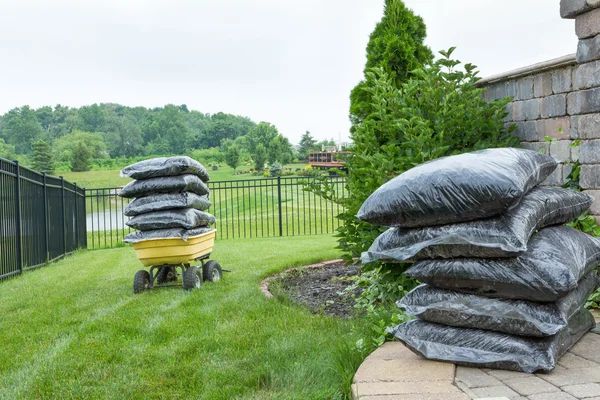 Eingesackter Mulch auf Tisch und Wagen im Hinterhof — Stockfoto