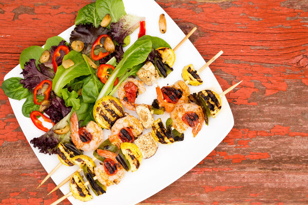 Креветки на тарелке с овощами и специями
