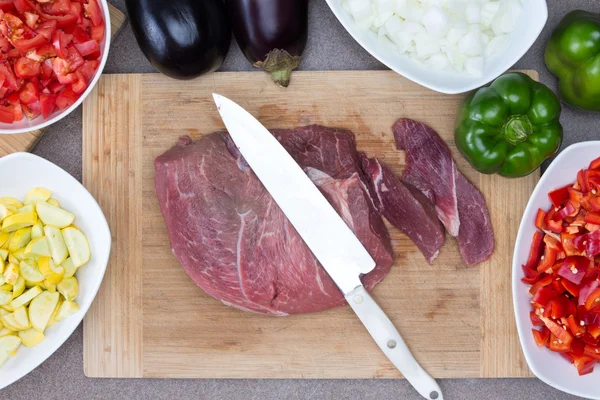 Carne en la tabla de cortar con ingredientes en los lados —  Fotos de Stock