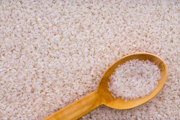 Grains de riz étuvés avec une cuillère en bois — Photo