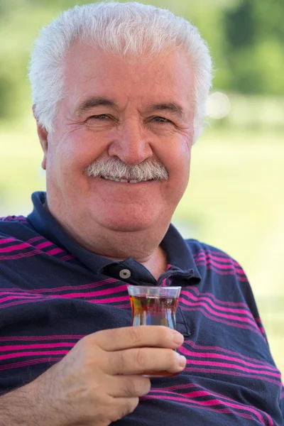 Glimlachend senior man genieten van een glas thee — Stockfoto