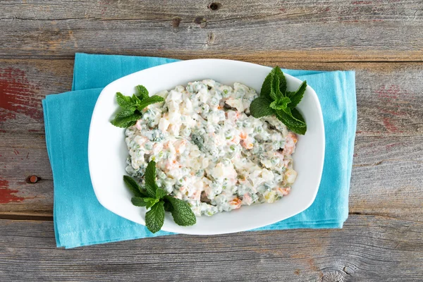 Simple Olivier Salad on old picnic table — Stock Photo, Image