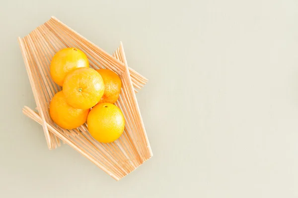 Naranjas frescas en bandeja de madera en la mesa —  Fotos de Stock