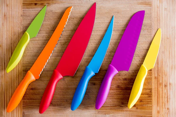 Colorful Kitchen Knives on Wooden Cutting Board — Stock Photo, Image