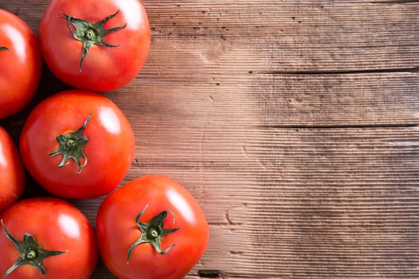 Frische rote Tomaten auf Holztisch mit Kopierraum — Stockfoto