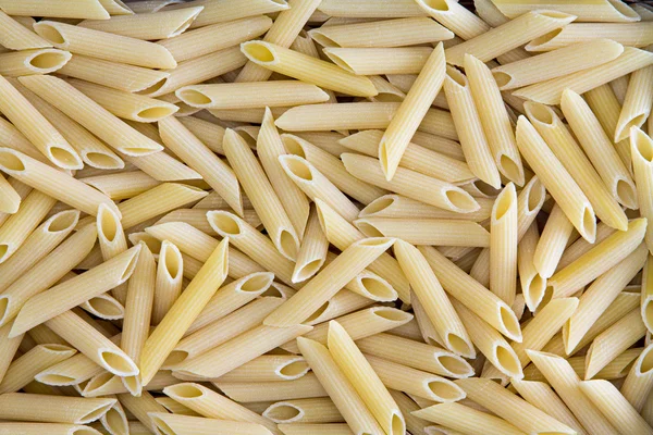 Background texture of penne, rigate or ziti pasta — Stock Photo, Image