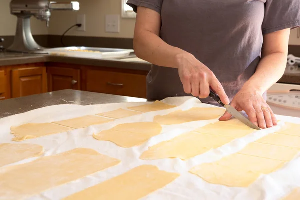 Шеф-повар обрезает тесто для макарон на кухне — стоковое фото
