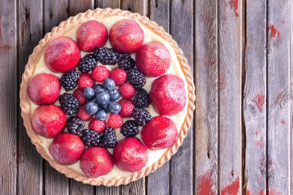 Leckere Torte mit frischen Beeren auf dem Tisch — Stockfoto