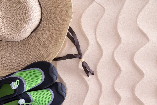 Boys beach hat and shoes on golden sand — Stock Photo, Image