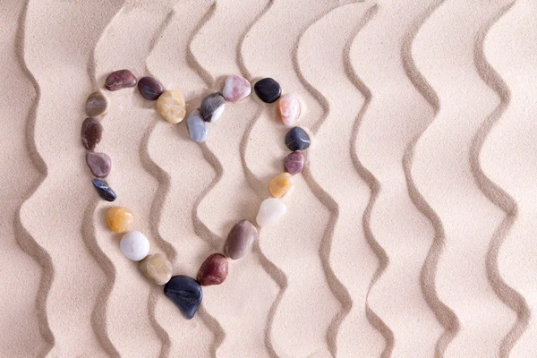 Decorative pebble heart on golden beach sand — Stock Photo, Image