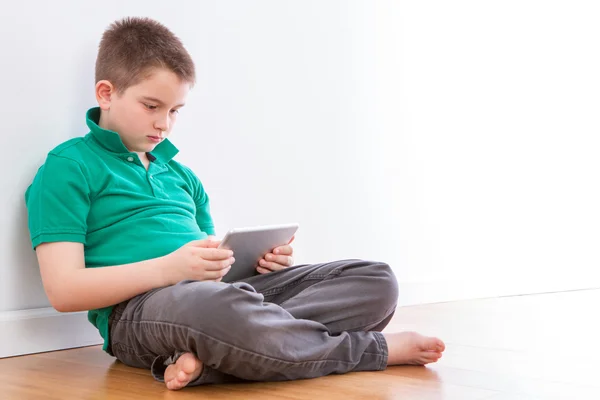 Beau jeune garçon avec tablette appuyée sur le mur — Photo