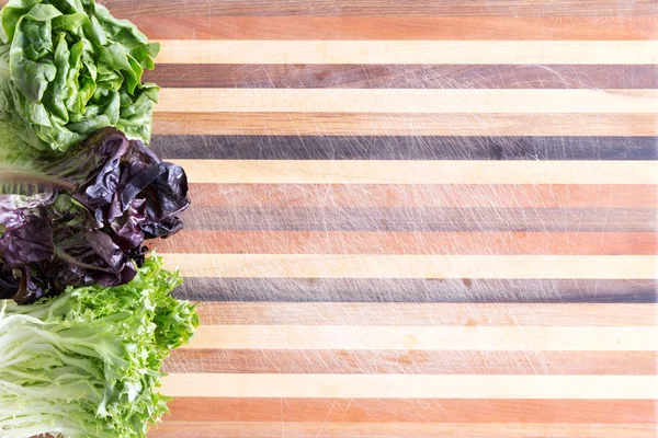 Fresh lettuce border on a decorative board — Stock Photo, Image