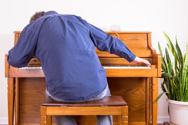 Enthusiastic man playing the piano with gusto clipart