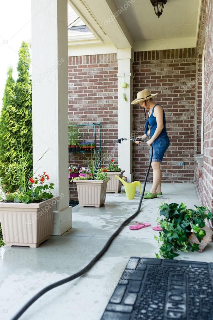 Woman gardener standing watering new plants