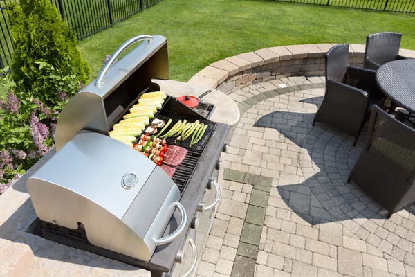 Grilling food on an outdoor gas barbecue — Stock Photo, Image