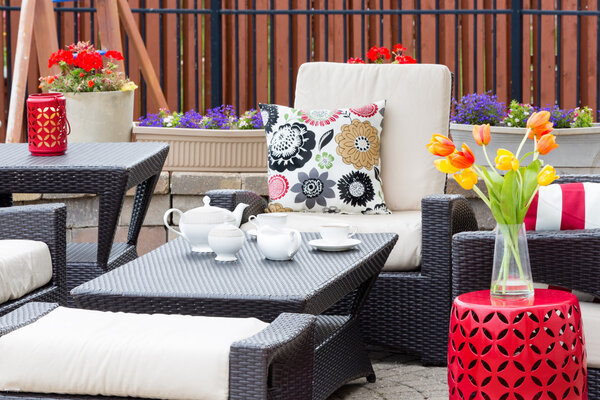 Чай подается на открытом патио между цветами
