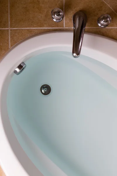 Oval bathtub full of clean water ready for a bath — Stock Photo, Image