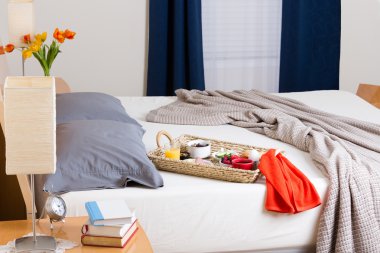 Breakfast Tray on Unmade Bed in Modern Bedroom