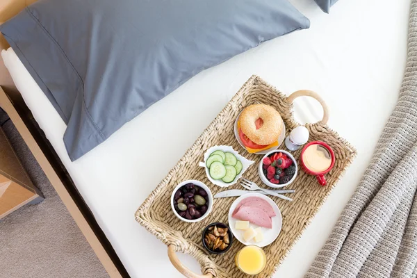 Vista de ángulo alto de la bandeja de desayuno en la cama sin hacer —  Fotos de Stock