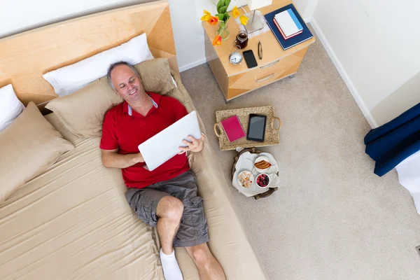 Man Lying on Bed with Laptop in Hotel Room — Stock Fotó